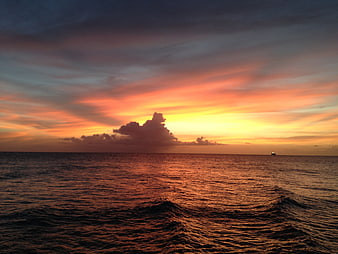 Dramatic Ocean Sunset With Silhouetted Clouds And Distant Ship