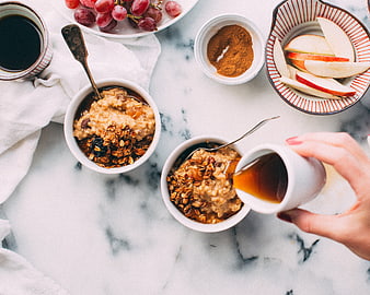 Overhead view of healthy oatmeal breakfast with honey, fruit, and coffee
