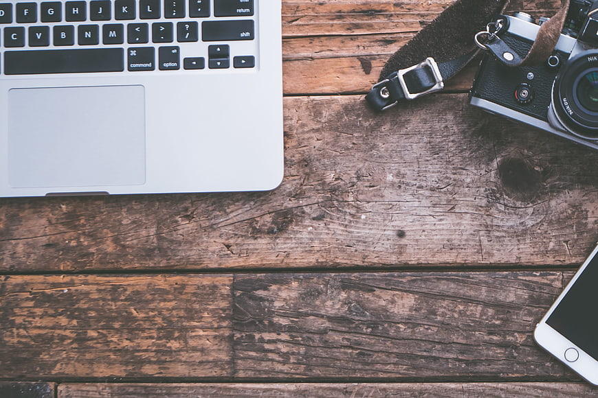 Rustic Workspace Flat Lay With Laptop, Camera, And Smartphone