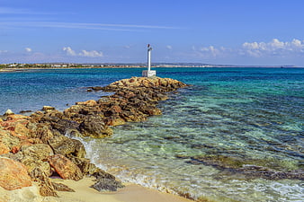 Rocky Jetty with Lighthouse in Turquoise Mediterranean Sea