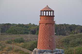Red Brick Miniature Lighthouse in Green Landscape