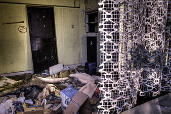 Abandoned room interior with debris and hanging netting