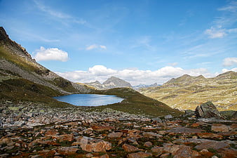 Alpine Lake Surrounded by Rocky Mountains Under Blue Sky