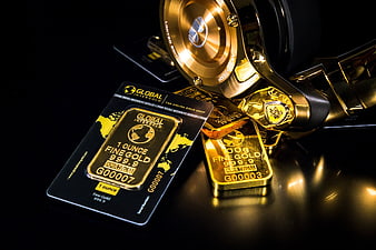 Gold bars, watch, and credit card on black background