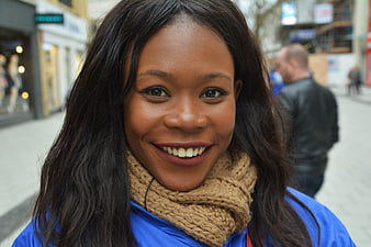 Smiling African American Woman Wearing Knit Scarf On City Street