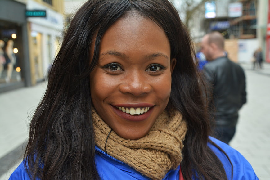Smiling African American Woman Wearing Knit Scarf On City Street