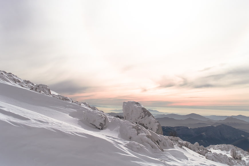 Snowy Mountain Ridge at Sunset with Distant Peaks