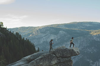 Couple hiking on granite rock formation in mountain landscape