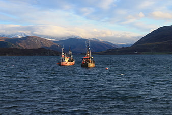 Fishing boats on a Scottish loch with mountains