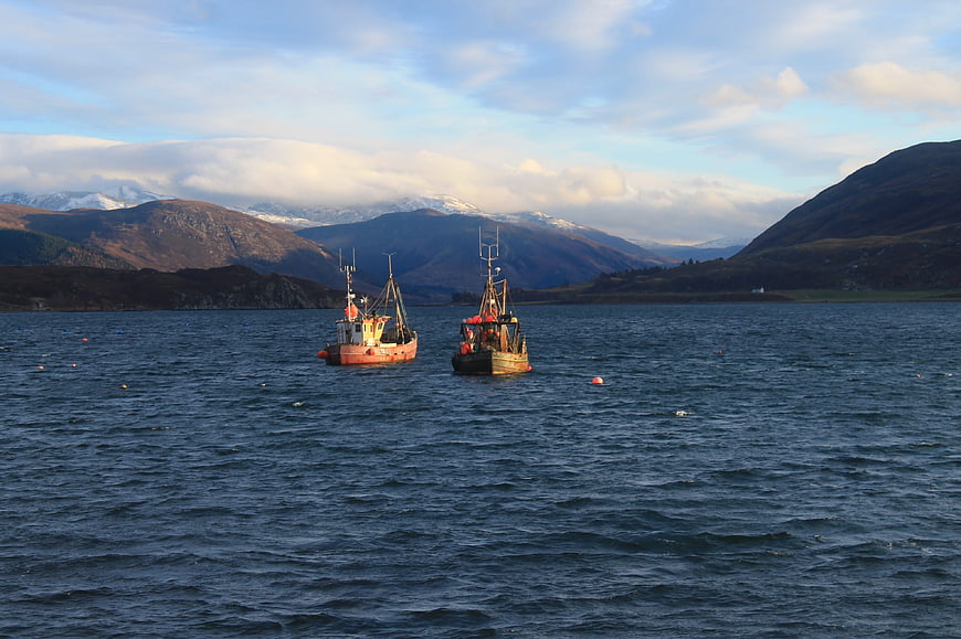 Fishing boats on a Scottish loch with mountains