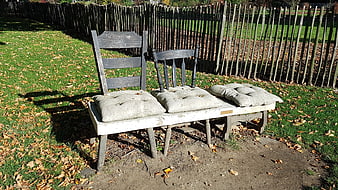 Rustic wooden chairs with cushions in autumn park