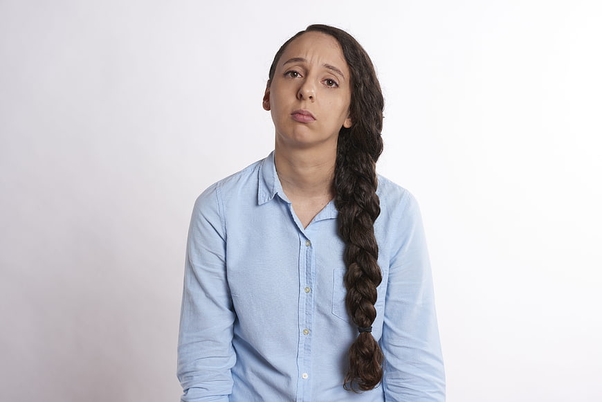 Portrait of a young woman with a long braid looking confused and skeptical