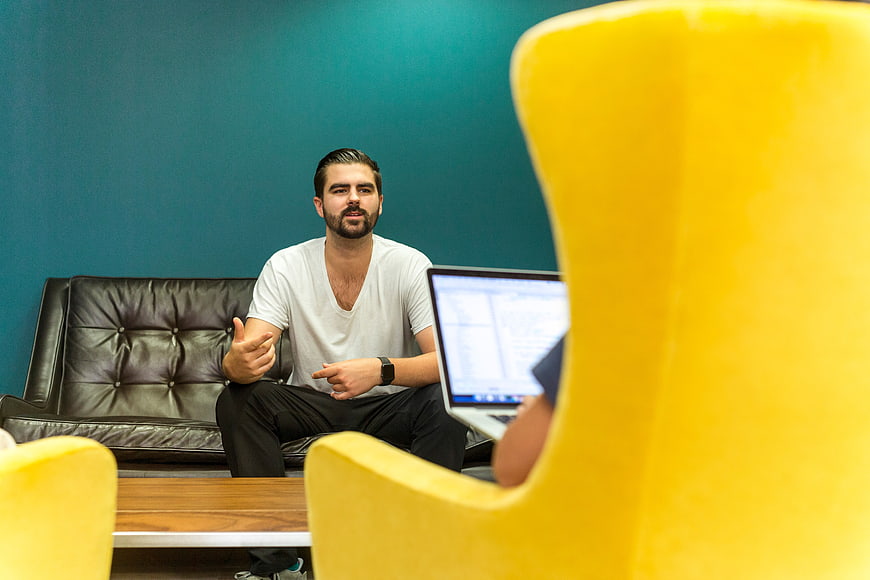 Man discussing work on laptop in modern office
