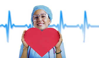 Smiling female nurse holding red heart with ECG background