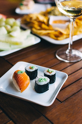Sushi and wine on wooden table at summer party