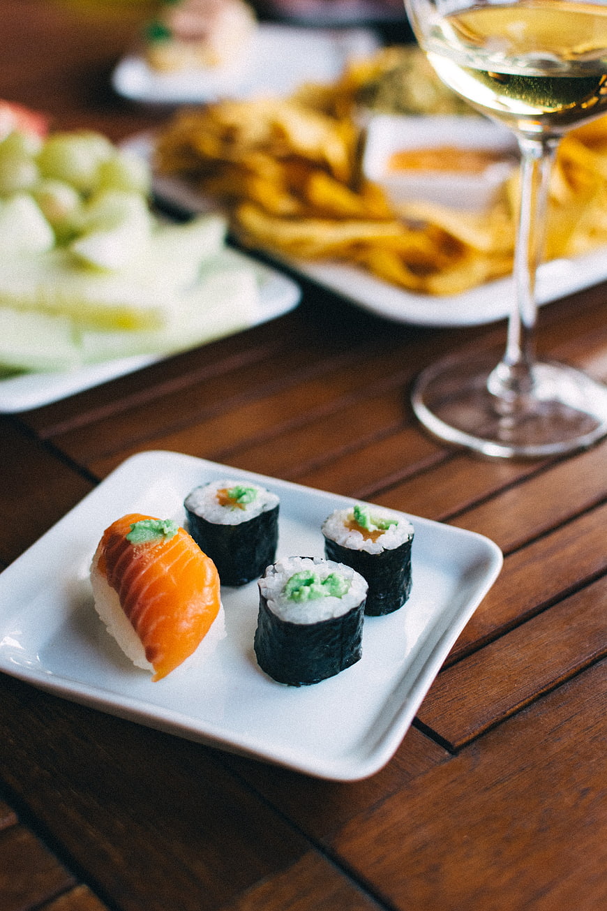 Sushi and wine on wooden table at summer party