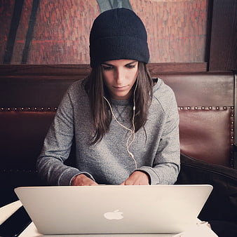 Woman in Beanie Working on Laptop in Cafe
