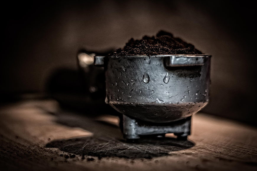 Close-up of metal portafilter with coffee grounds