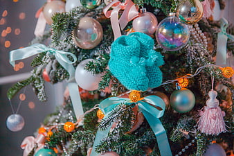 Close-up of knitted baby booties on a decorated Christmas tree
