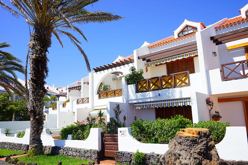 White Mediterranean Holiday Apartments With Palm Trees And Blue Sky