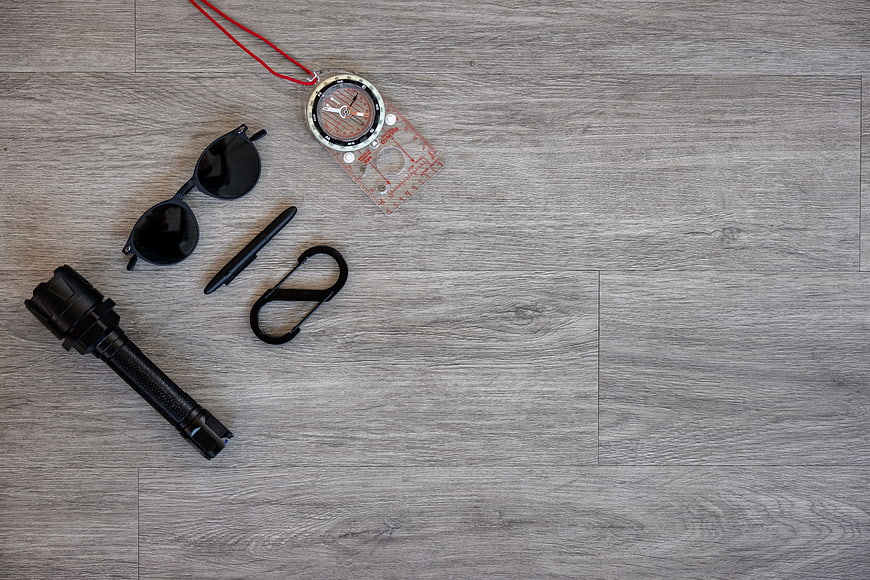 Top view of hiking gear on gray wood background