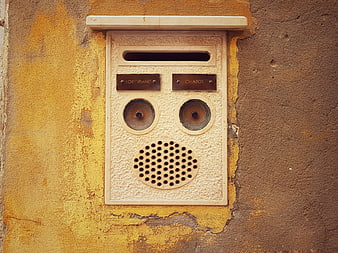 Vintage intercom panel on textured yellow wall