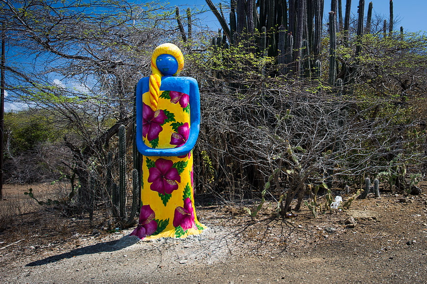 Colorful Sculpture of Woman in Floral Dress in Desert