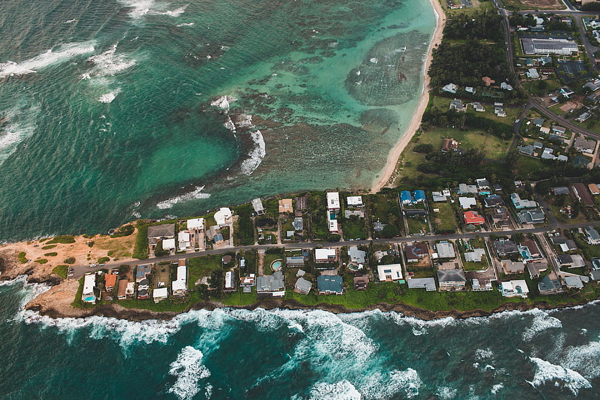 Aerial View of Coastal Town with Turquoise Ocean and Waves