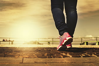 Low angle view of woman walking on cobblestone path