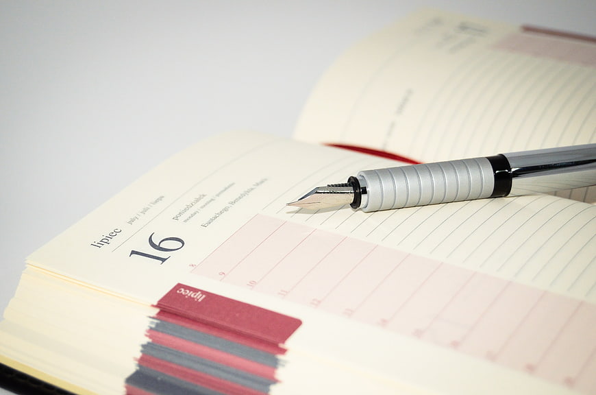 Fountain Pen Resting On Open Planner With Tabbed Index
