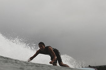Surfer riding wave on overcast day