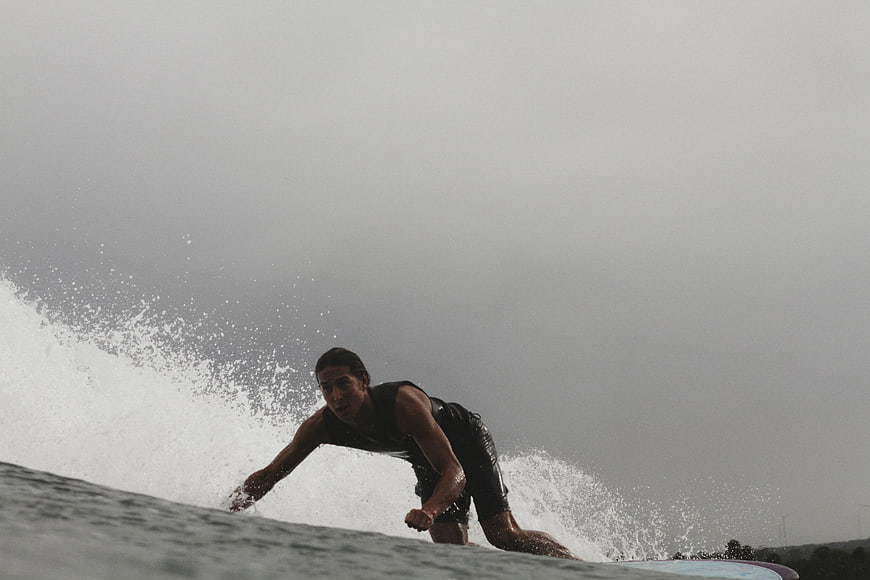 Surfer riding wave on overcast day