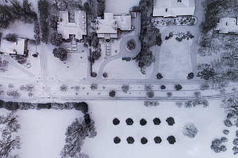 Aerial view of snow-covered suburban neighborhood with houses and trees