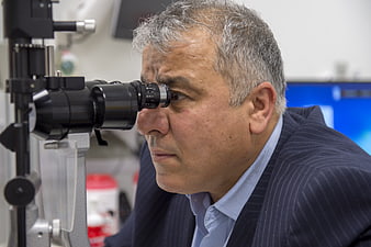 Senior Ophthalmologist Examining Eye With Slit Lamp Microscope