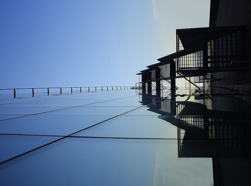 Modern Glass Building Facade with Blue Sky Reflection