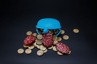Blue Piggy Bank With Coins And Sausage Slices On Black Background