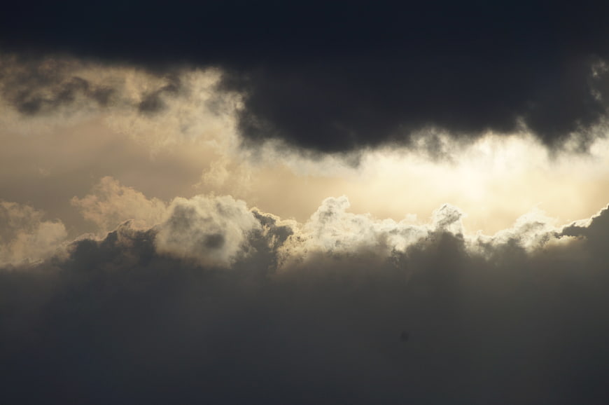 Dramatic Sunlight Breaking Through Dark Storm Clouds