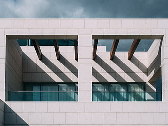 Modern architectural facade with geometric shadows and stone cladding