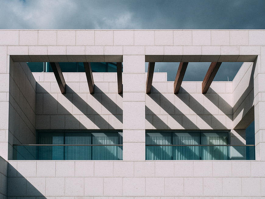 Modern architectural facade with geometric shadows and stone cladding