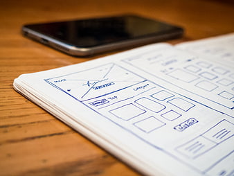 Hand-drawn mobile app wireframe sketch on notebook
