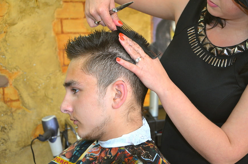 Young man getting haircut in salon