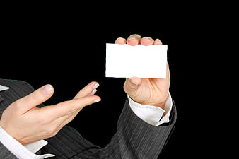 Businessperson holding blank white business card against black background