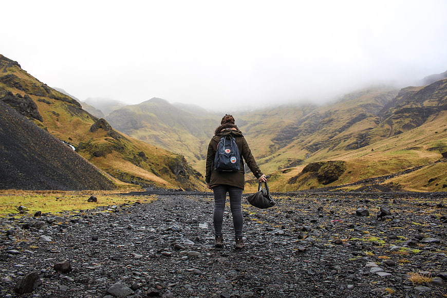 Hiker Walking on Rocky Path in Foggy Mountain Valley