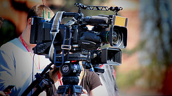 Professional Video Camera on Tripod Filming Outdoors