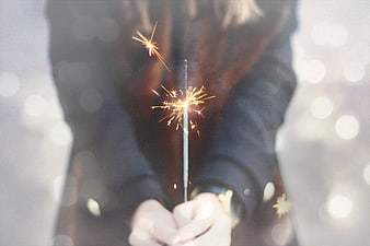Woman holding sparkler with bokeh background