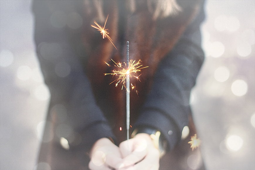 Woman holding sparkler with bokeh background