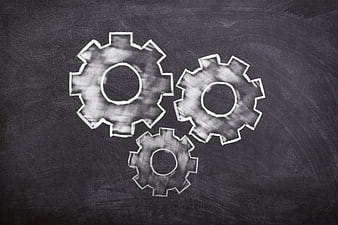 Chalk-drawn gears on a dark blackboard background