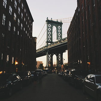Manhattan Bridge View Between Brick Buildings at Dusk
