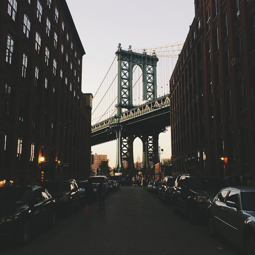 Manhattan Bridge View Between Brick Buildings at Dusk