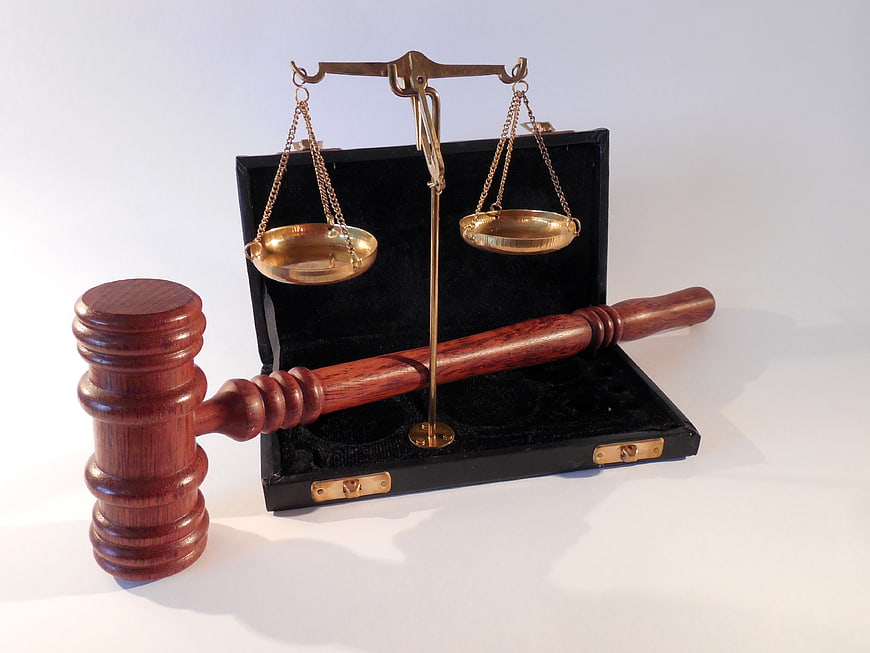 Wooden Gavel and Brass Scales of Justice on White Background